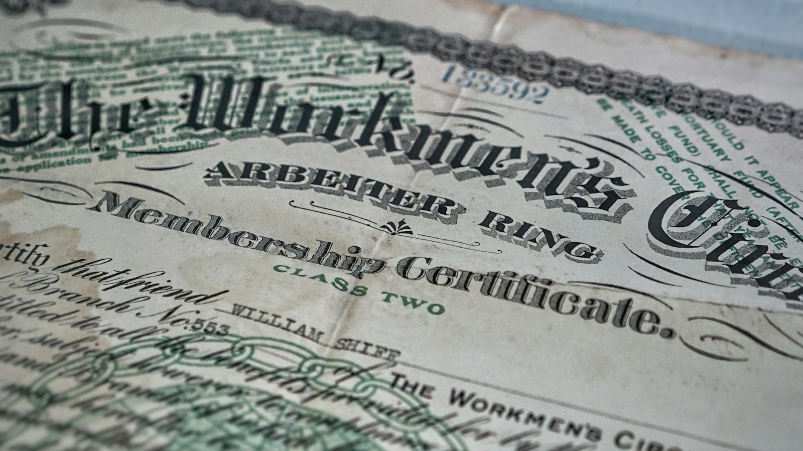 Membership certificate document on a desk — overhead flat-lay representing the formal credential issued at the end of the EPA Lead-Safe certification process.