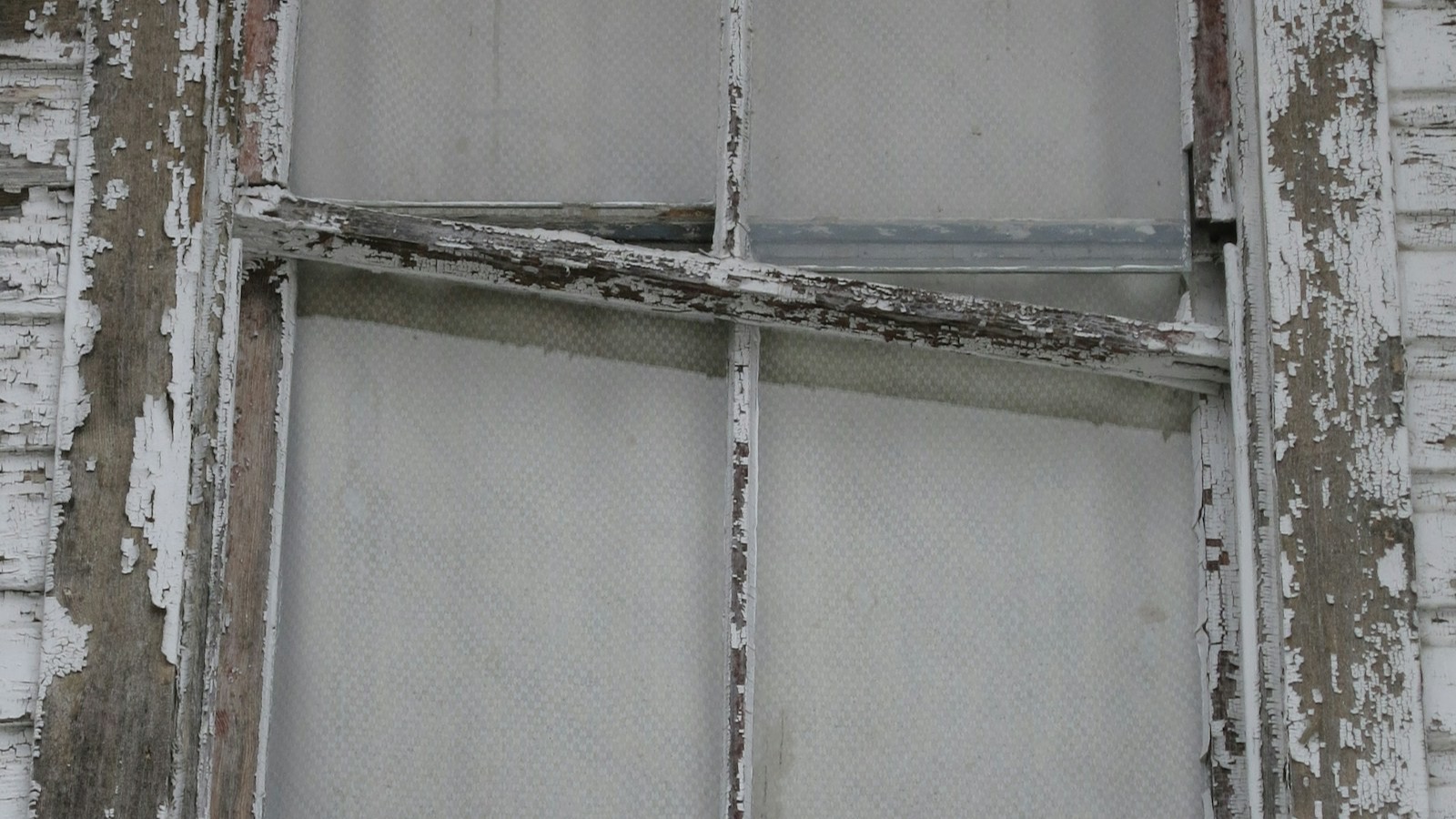 Weathered painted window sash on a pre-1978 home exterior showing layered, aging paint — the substrate Michigan's new universal blood-lead testing law will increasingly surface as a contributor to elevated levels.